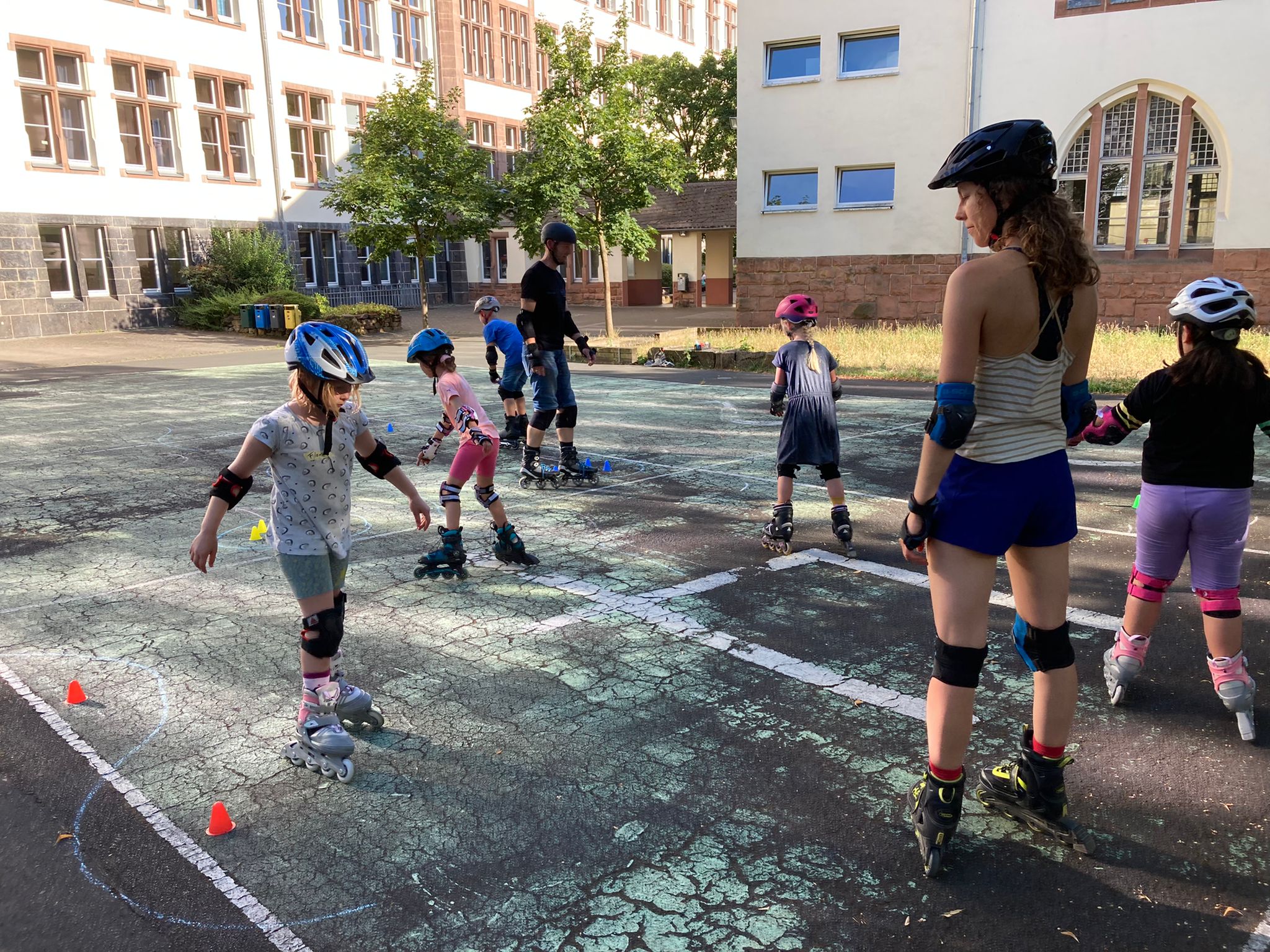 Kinder machen Fahrübungen in Inlineskate-Kurs
